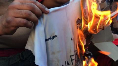 A River Plate fan sets a Boca Juniors shirt alight