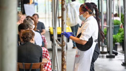 A waitress serving customers at a New York City restaurant