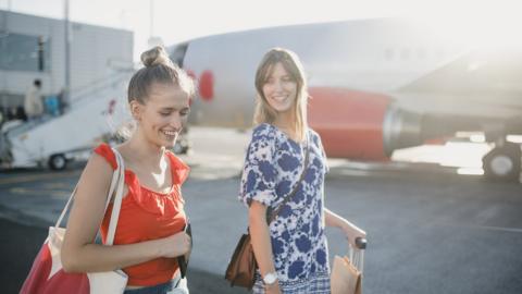 Young couple are boarding their plane at the airport to go on holiday