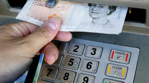 A person using a cashpoint