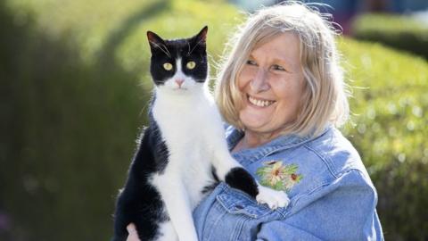 Black-and-white cat Zebby with his owner