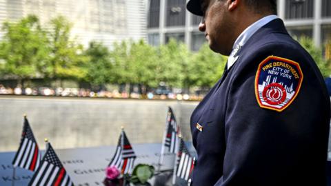 A Fire fighter visits the 9/11 memorial on 11 September 2023 in New York City, US