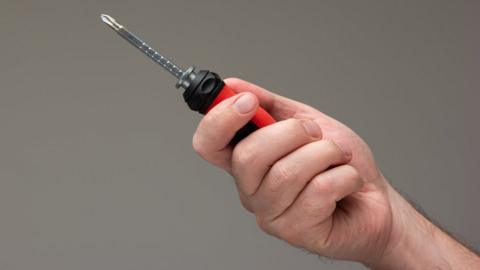 Person holding a screwdriver