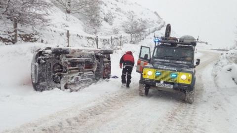 The Woodhead mountain rescue team check an overturned car