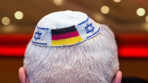 A man wearing a Jewish kippa skullcap with the flags of Germany and Israel in this 2014 file photo