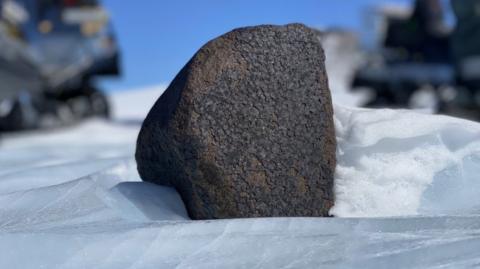 Asteroid, small rock with snow in background