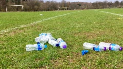 Used water bottles left on a football pitch