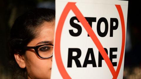 An Indian social activist holds a placard during a protest against a rape at Hauz Khas village in New Delhi on February 21, 2017