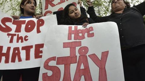 Immigration protestors hold signs.