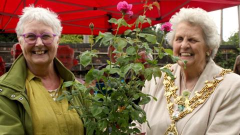 Pat Smith and Anne Cheetham with the rose for Sylvia Lancaster