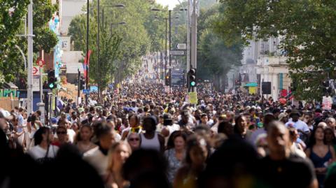 A general view of large crowds at Notting Hill Carnival and people filling the street. 