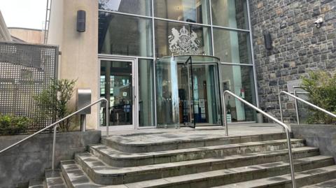 Guernsey Royal Court exterior - there are stairs leading to the building which has revolving doors.