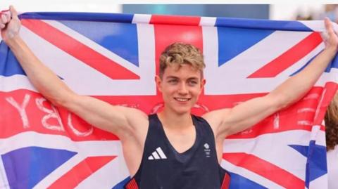 Toby Roberts holding union flag after winning Olympic gold