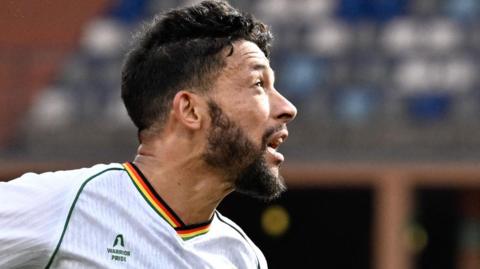 Macauley Bonne goes up for a header against Angola at the Africa Cup of Nations