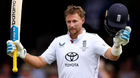England batter Joe Root raises his bat and helmet to celebrate hitting his 41st Test century