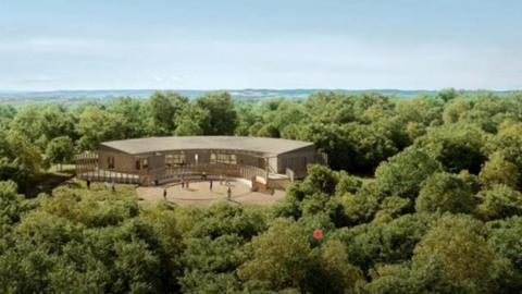 A CGI image of the new visitor centre at Ham Hill in the middle of a woodland. It is a curved building with a flat rood and the external walls appear to be made of wood