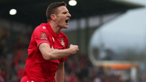 Paul Mullin in a Wrexham shirt celebrates a goal