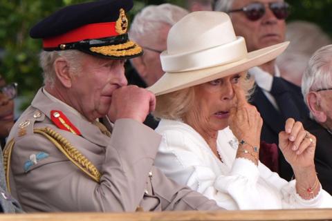 King Charles III and Queen Camilla react to veteran Yavar Abbas's reference to the King's cancer treatment during the national Service of Remembrance, hosted by the Royal British Legion in partnership with the Government, to mark the 80th Anniversary of VJ Day at The National Memorial Arboretum on August 15, 2025 in Alrewas, Staffordshire. The service commemorates the 80th Anniversary of Victory over Japan Day, or VJ Day, which marks the announcement of Japan's acceptance of the terms of the Potsdam Declaration on August 15, 1945, effectively bringing WWII to an end. 