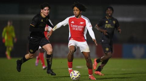 Louis Zecevic-John of Arsenal runs with the ball