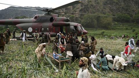 People load injured persons onto a helicopter in Afghanistan