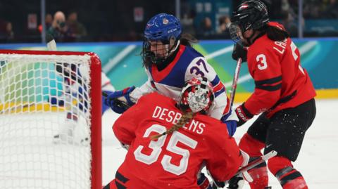 Ann-Renee Desbiens #35 and Jocelyne Larocque #3 of Team Canada defend the net against Abbey Murphy #37 of Team United States in the first period during the Women's Preliminary Group A match between United States and Canada on day four of the Milano Cortina 2026 Winter Olympic games 