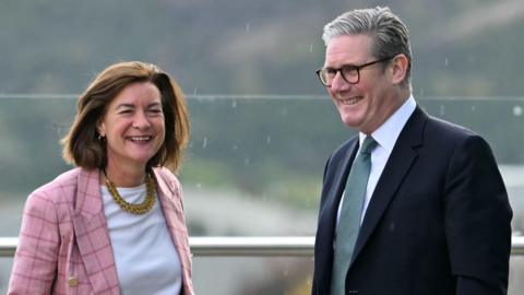 Prime Minister Sir Keir Starmer speaks with Wales' First Minister Eluned Morgan, they are both smiling  