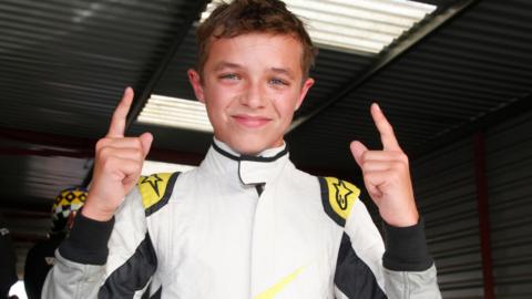Norris celebrates by holding both index fingers in the air at Knockhill in 2014