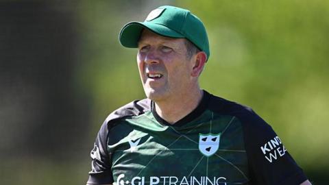 Alan Richardson takes a training session for Worcestershire. He is wearing a club green and back shirt and has a green baseball cap on.