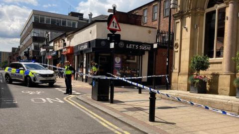 Police officers outside a police cordon