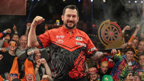 Jonny Clayton celebrates with the trophy
