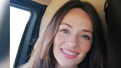 Charlotte Beynon pictured in the front seat of a car smiling at the camera. She has long brown hair 