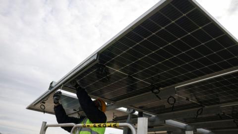 A man installing a solar panel