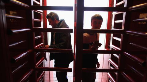 Football fans going through turnstiles