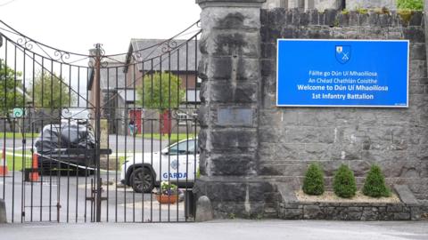 A car wrapped in black plastic and a garda car at the scene at Renmore Barracks in County Galway, after an army chaplain was stabbed