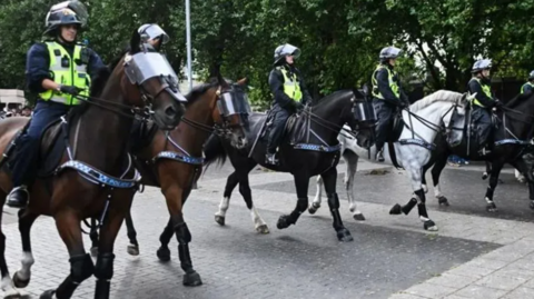 Police horses lined up during the disorder in Bristol on the edge of Castle Park.