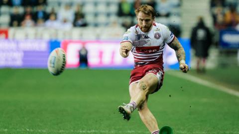 Adam Keighran of Wigan kicks for goal.