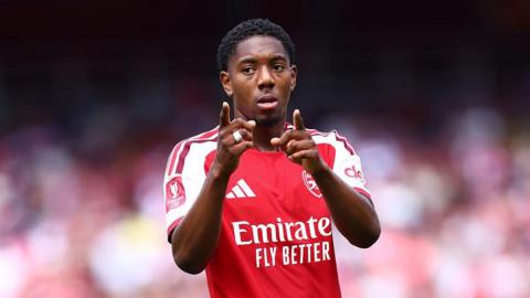 Myles Lewis-Skelly of Arsenal points at the camera