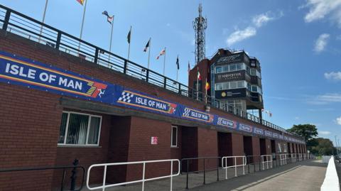 The TT grandstand, which has Classic TT branding below the railings and advertising on the control tower.