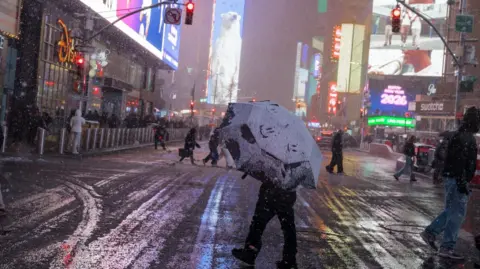 A person crosses the street during the winter blizzard in New York, New York, USA, 22 February 2026. The National Weather Service has issued a blizzard warning for New York City, forecasting up to 24 inches of snow. 