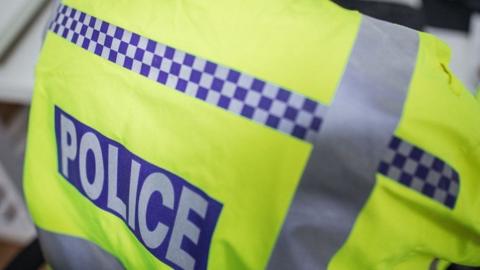 A stock photo of a police officer's jacket with the word POLICE emblazoned across the back.