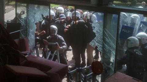 Riot police breaking the entrance door of the CHP's headquarters