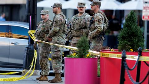 Yellow police tape surrounds four National Guardsmen who are standing close to the scene where two West Virginia National Guard members were shot in Washington, DC, USA