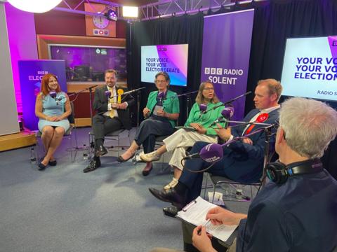Candidates chatting in the purple, Radio Solent studio with presenter sat to the right handside