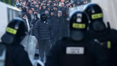 Police stand guard as protests take place following a night of anti-immigrant riots on June 10