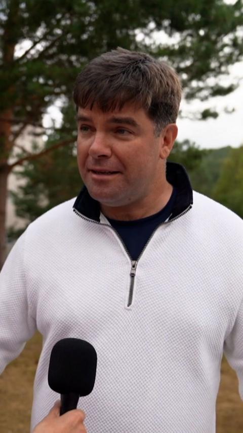 Man with brown hair and white half zip