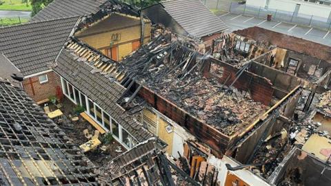 Aerial shot of fire damaged church with roof missing