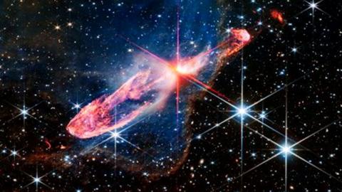 A red star in the process of  forming against a field of stars.