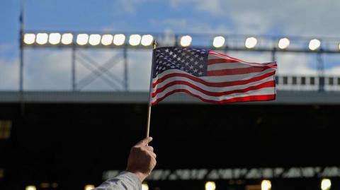 An American flag held up at a football stadium