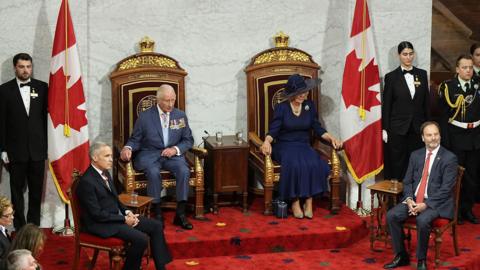 King Charles III and Queen Camilla, sit in thrones, beside Prime Minister of Canada Mark Carney (front of steps, left) and Senator Marc Gold (front right), Government Representative in the Senate, in the Senate Chamber at the Senate of Canada Building, Ottawa, for the State Opening of the Parliament of Canada,
