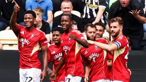 Salford City players celebrate scoring against Notts County